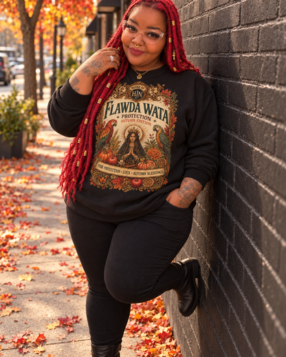 Model with red locs wearing a black Flawda Wata Fall sweatshirt with autumn leaves, pumpkins and an ornate botanical graphic